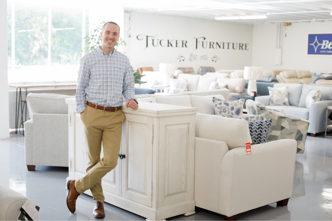 Owner of Charlotte furniture store leaning on a sectional sofa